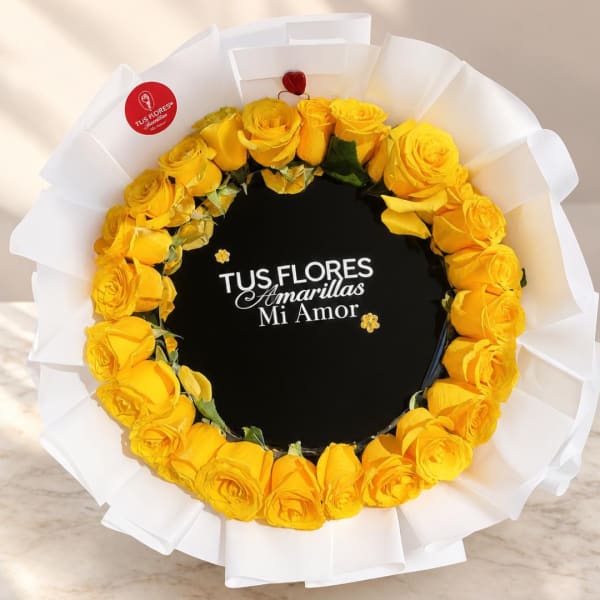 Round bouquet of yellow roses wrapped in white paper
