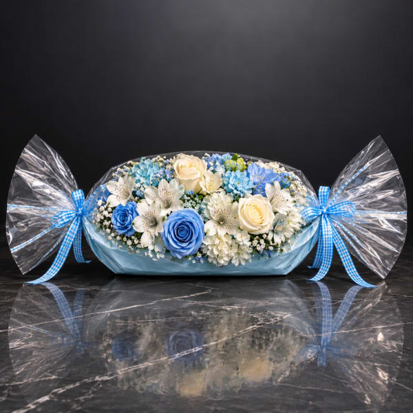 Blue and white flower arrangement wrapped like a candy with ribbon bows