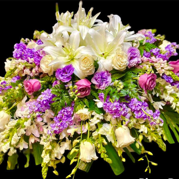 Large bouquet of white lilies, cream roses, and purple flowers