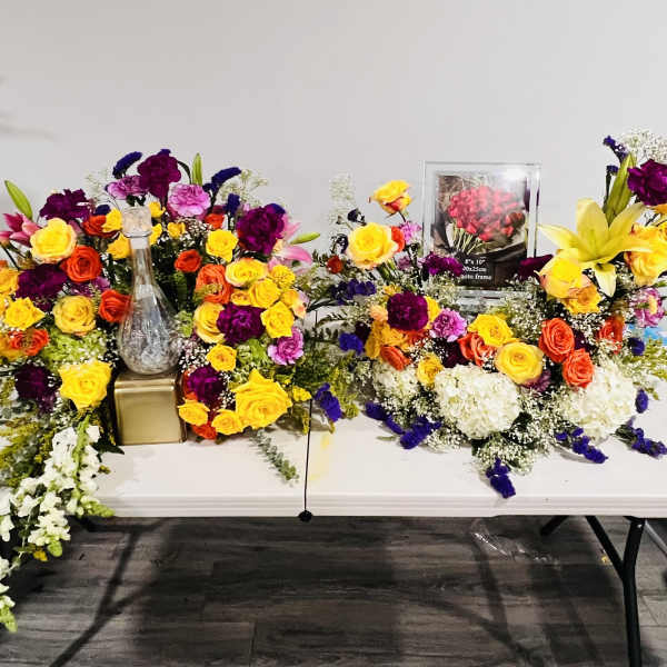 Colorful floral arrangements with roses, lilies, and carnations on a table