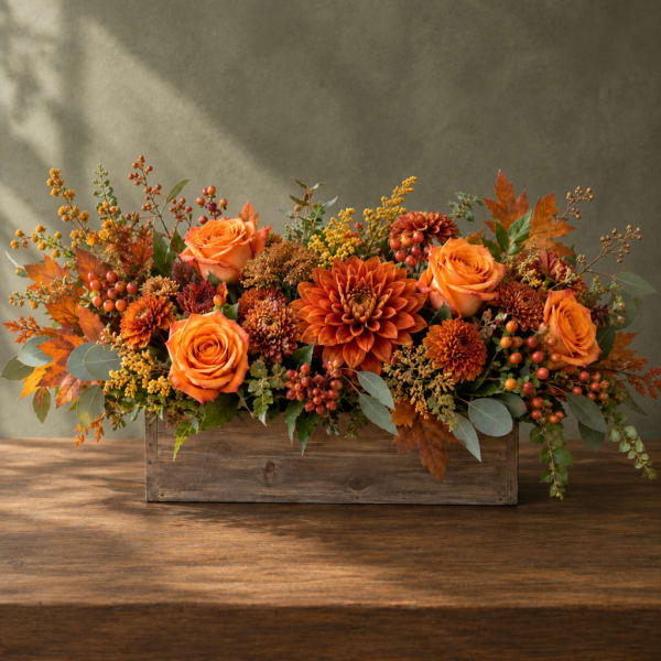 Orange roses and mums arranged in a rustic wooden box