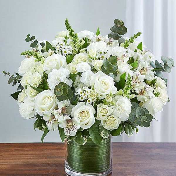 White rose bouquet in a glass vase with eucalyptus accents