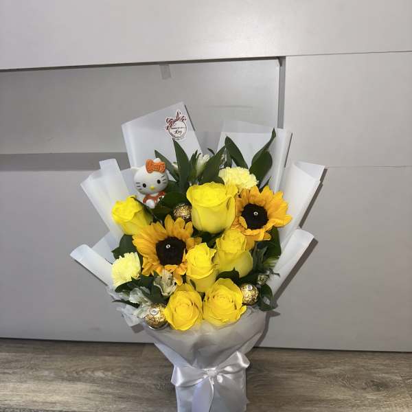 Yellow roses and sunflowers in white wrap with a Hello Kitty topper