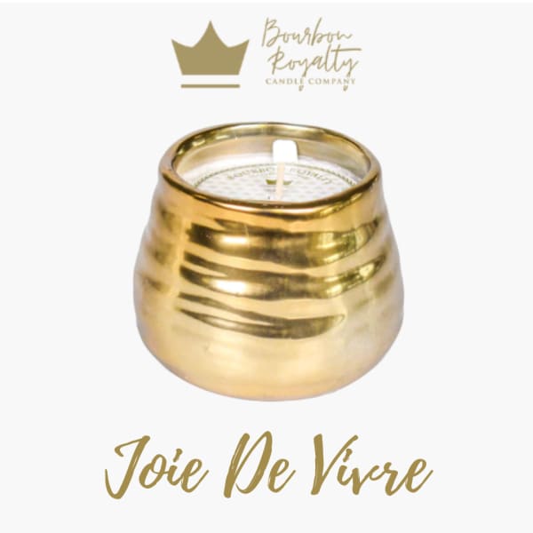 Gold candle in a rounded metallic holder with a white wick