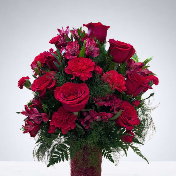 Red roses and carnations arranged in a glittery vase