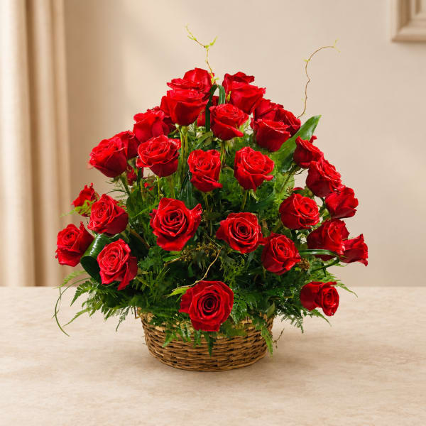 Basket arrangement of red roses with greenery