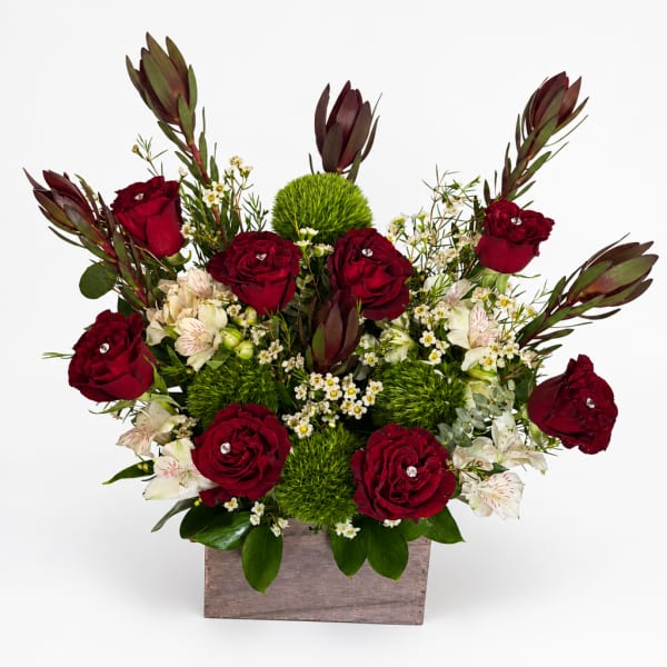 Red roses and white flowers arranged in a wooden box
