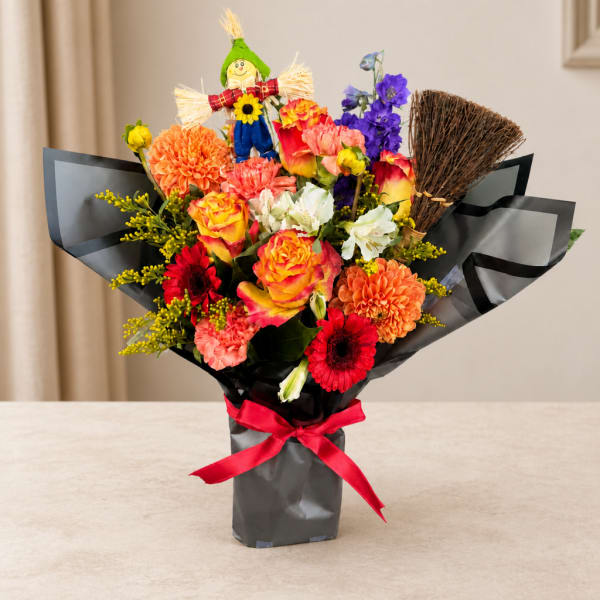 Colorful mixed bouquet with a scarecrow pick in black wrap and red ribbon