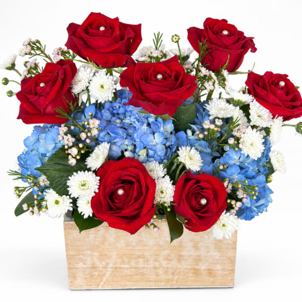 Red roses and blue hydrangeas in a wooden box