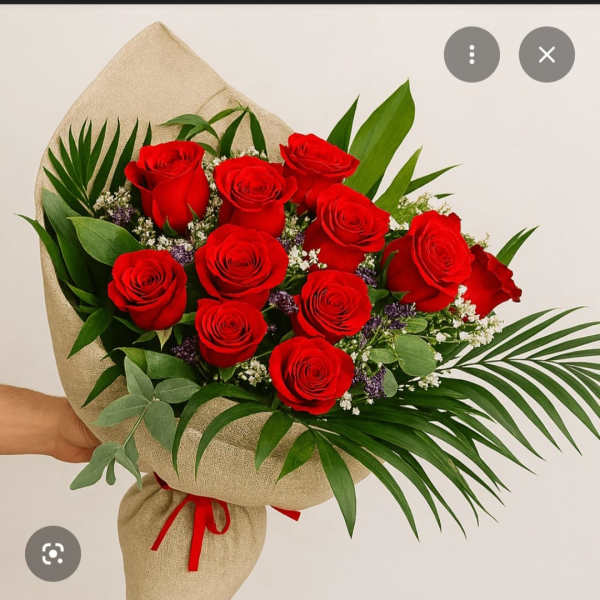 Bouquet of red roses wrapped in burlap with palm leaves
