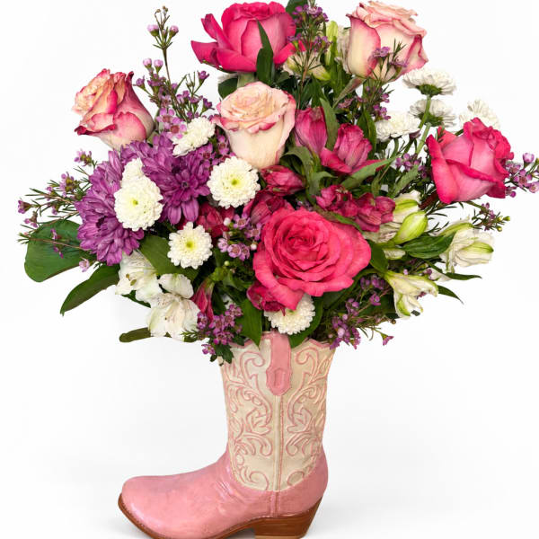 Mixed pink and white flower arrangement in a pink cowboy boot vase