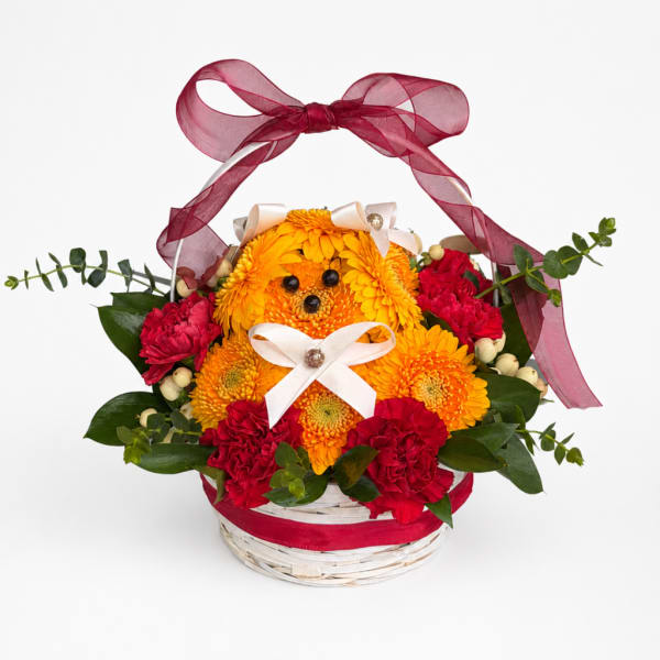 Basket arrangement with yellow and red flowers and a burgundy ribbon bow