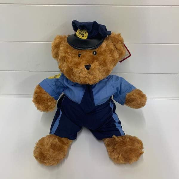 Teddy bear dressed in a blue firefighter uniform and hat