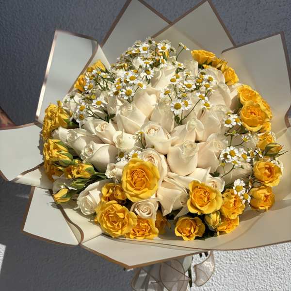 Bouquet of white and yellow roses with small white daisies