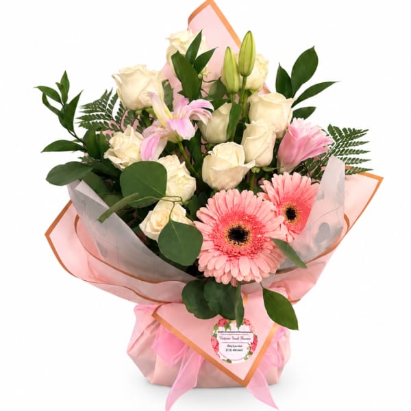Pink and cream bouquet with roses, lilies, and gerbera daisies in pink wrap