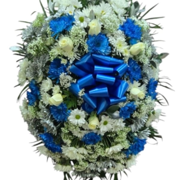 Blue and white funeral wreath on a standing easel with a large blue bow