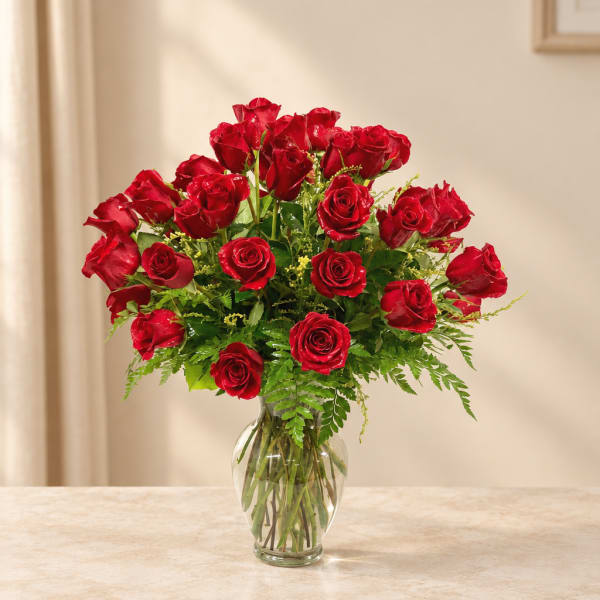 Red roses arranged in a clear glass vase