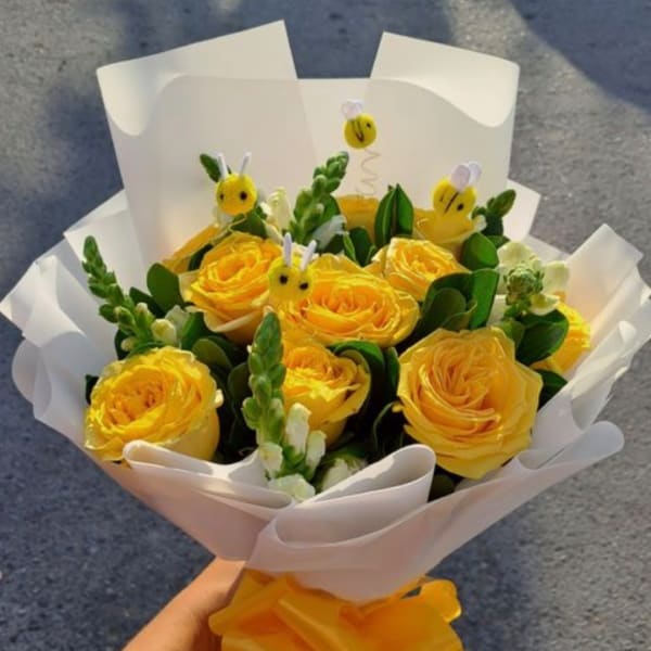 Yellow rose bouquet with white wrap and small bee decorations