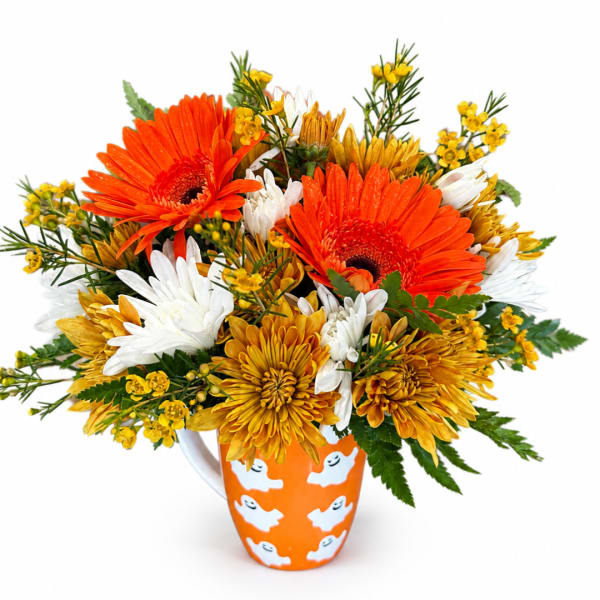 Orange and yellow mixed flower bouquet in a Halloween mug