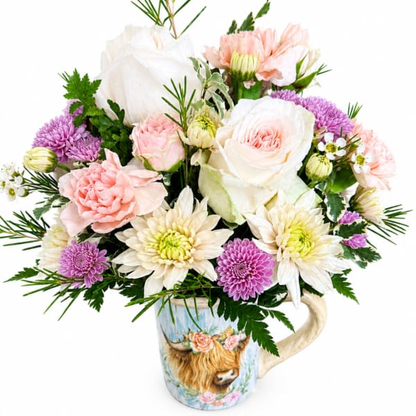 Bouquet of pink, white, and purple flowers in a decorative mug vase