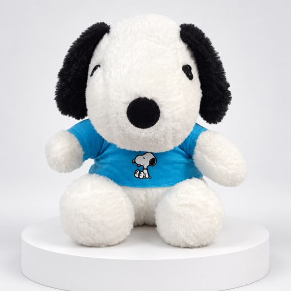 Plush Snoopy stuffed animal wearing a blue shirt on a white pedestal