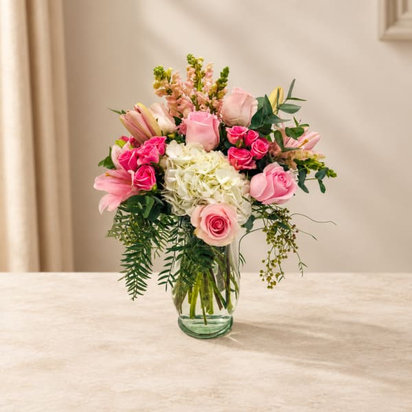 Pink and white flower arrangement in a clear glass vase