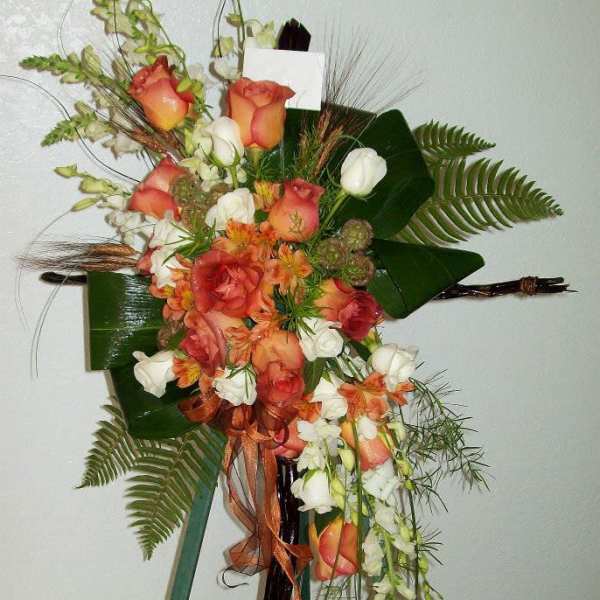 Tall floral spray with peach roses and white blooms on a stand