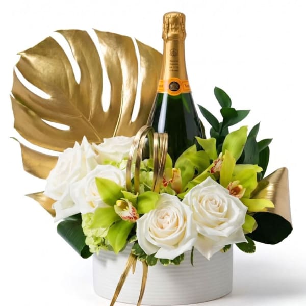 White roses and green orchids arranged in a white box with a champagne bottle