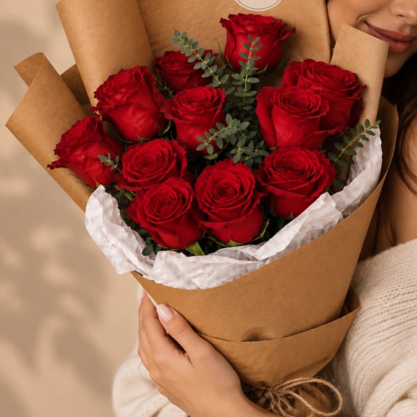 Bouquet of red roses wrapped in brown paper