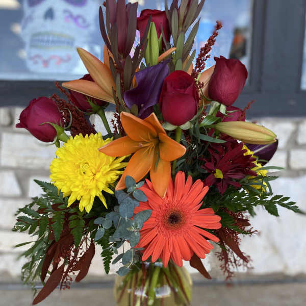 Mixed bouquet in a glass vase with roses, lilies, gerbera daisies, and chrysanthemums