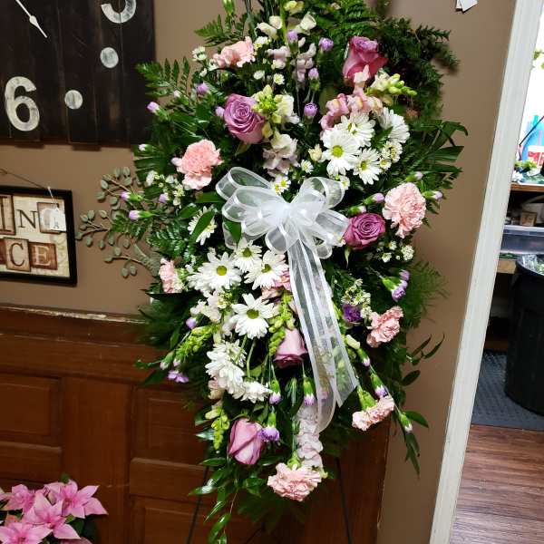 Standing floral spray with pink and white flowers and a white ribbon bow