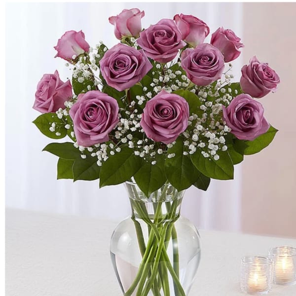 Pink roses arranged in a clear glass vase with white filler flowers