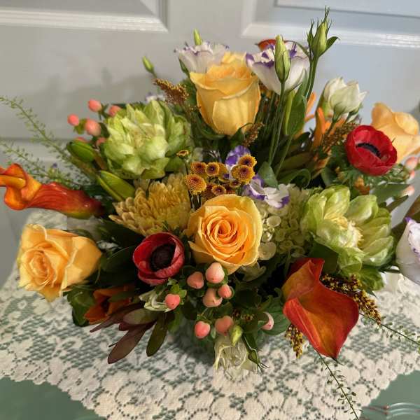 Mixed bouquet with yellow roses, red anemones, and orange calla lilies