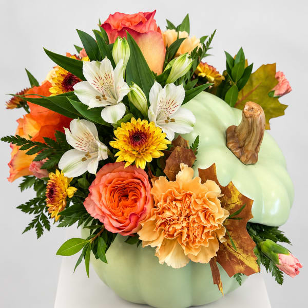 Pumpkin-shaped floral arrangement with orange, white, and yellow blooms
