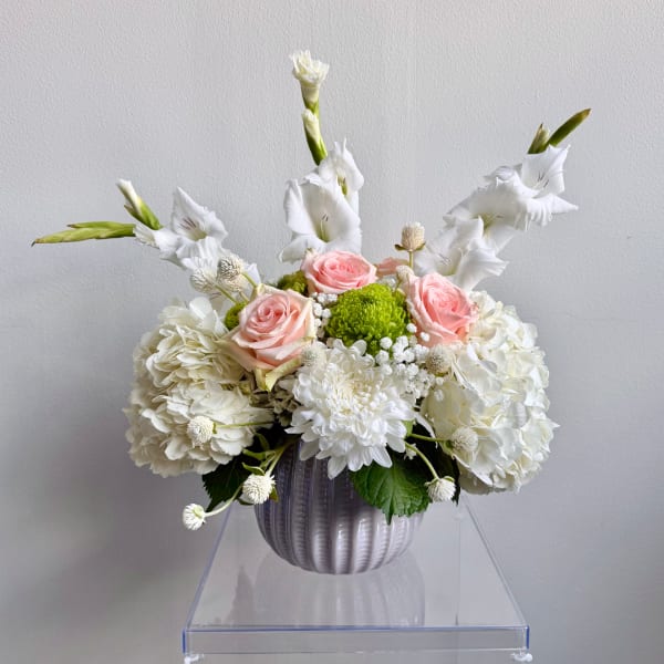 White and pink floral arrangement in a ribbed vase