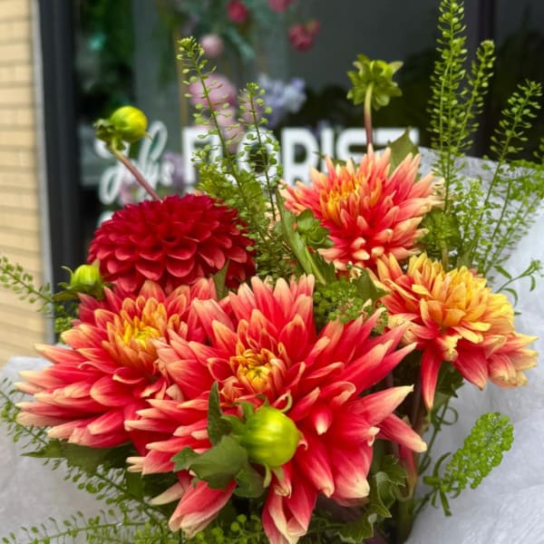 Bouquet of red and peach dahlias with green accents