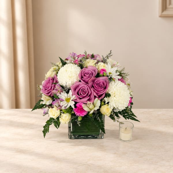 Pink and white flower arrangement in a square glass vase