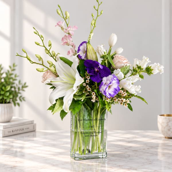Mixed bouquet of lilies, orchids, and roses in a clear glass vase
