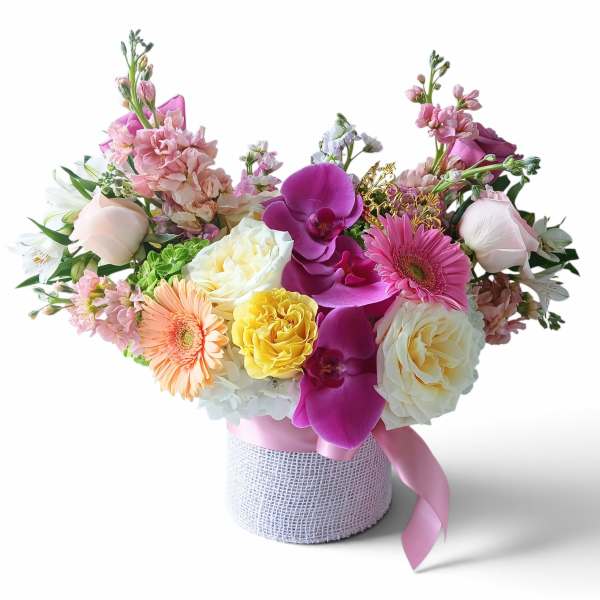 Colorful bouquet in a wrapped round box with roses, gerberas, and orchids