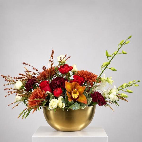Mixed bouquet in a gold bowl with red, white, and orange flowers