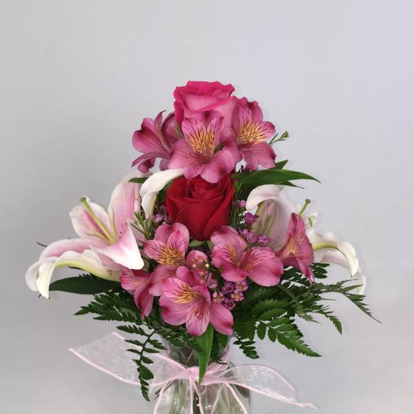 Pink and white mixed bouquet in a glass vase with a ribbon