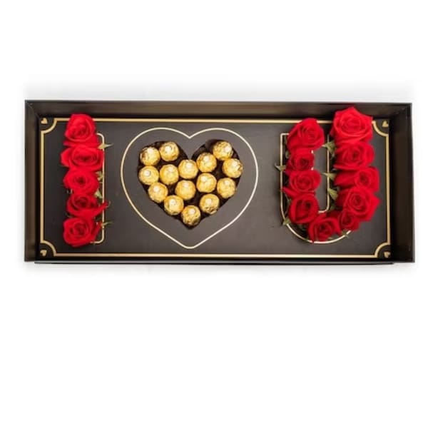 Heart-shaped chocolate box with red roses arranged around it