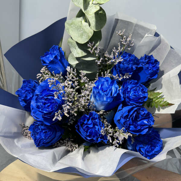 Bouquet of vivid blue roses with white filler and eucalyptus
