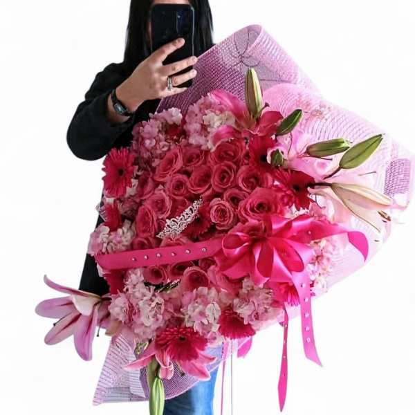 Large pink bouquet with roses, lilies, and gerbera daisies wrapped in pink mesh
