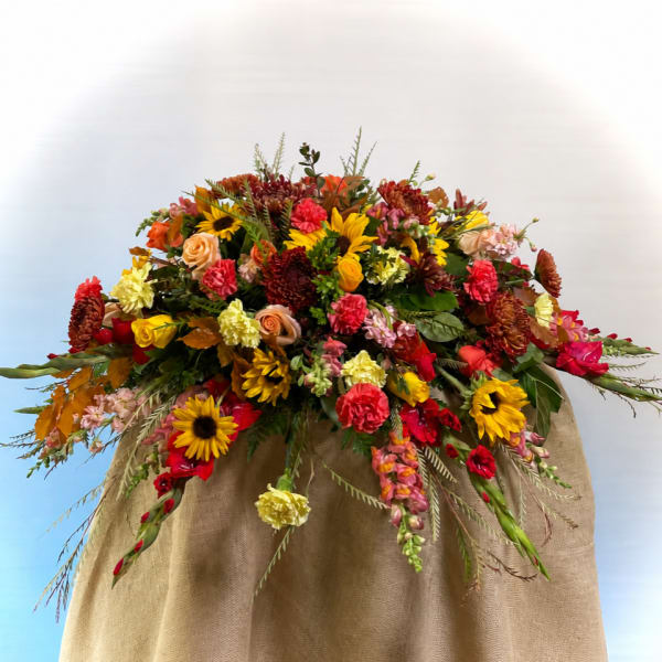 Large mixed bouquet with sunflowers, roses, and carnations in warm fall colors