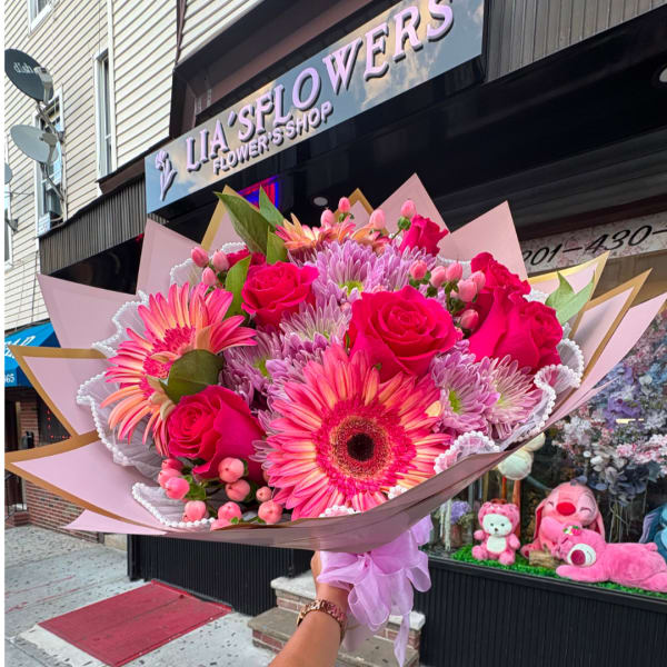 Pink mixed bouquet with roses and gerbera daisies wrapped in pastel paper