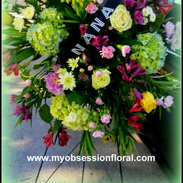 Large standing floral spray with roses, hydrangeas, and mixed blooms