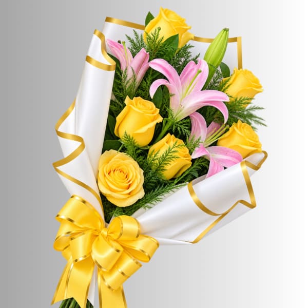 Bouquet of yellow roses and pink lilies wrapped in white paper with a gold ribbon