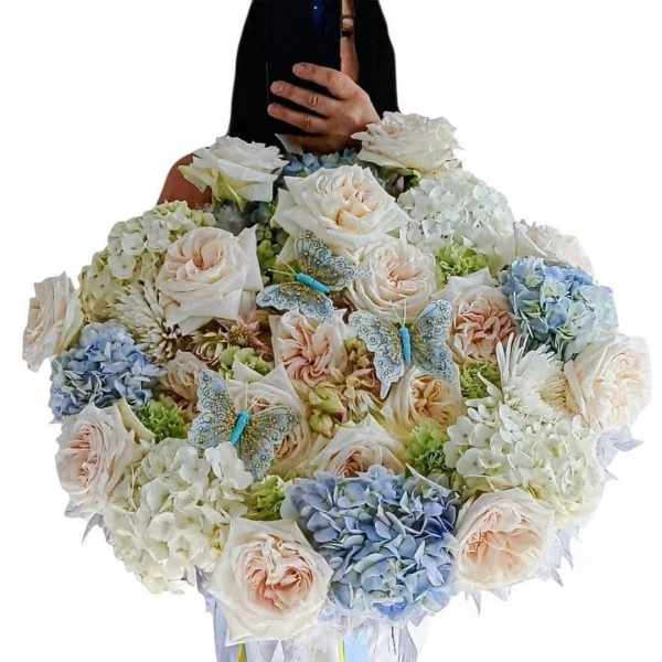 Large bouquet of pale roses and hydrangeas with butterfly decorations