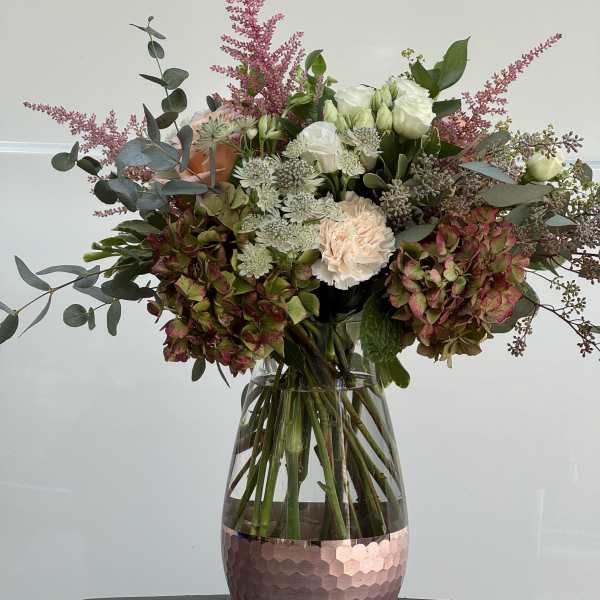 Mixed bouquet of white and blush flowers in a glass vase